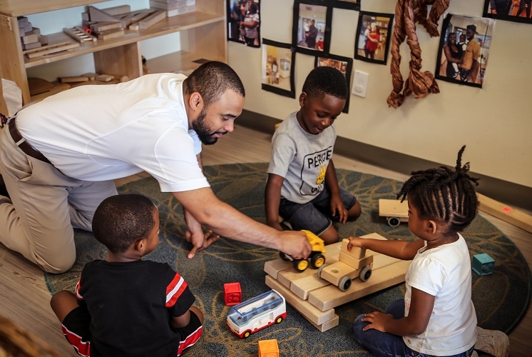 teacher and children building a bridge from blocks